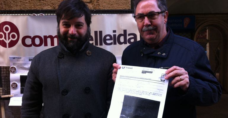 Alfred Sesma i Joaquim Manau mostrant la fotocòpia de la multa al vehicle oficial a l'AP-2 el 24 de maig de 2012