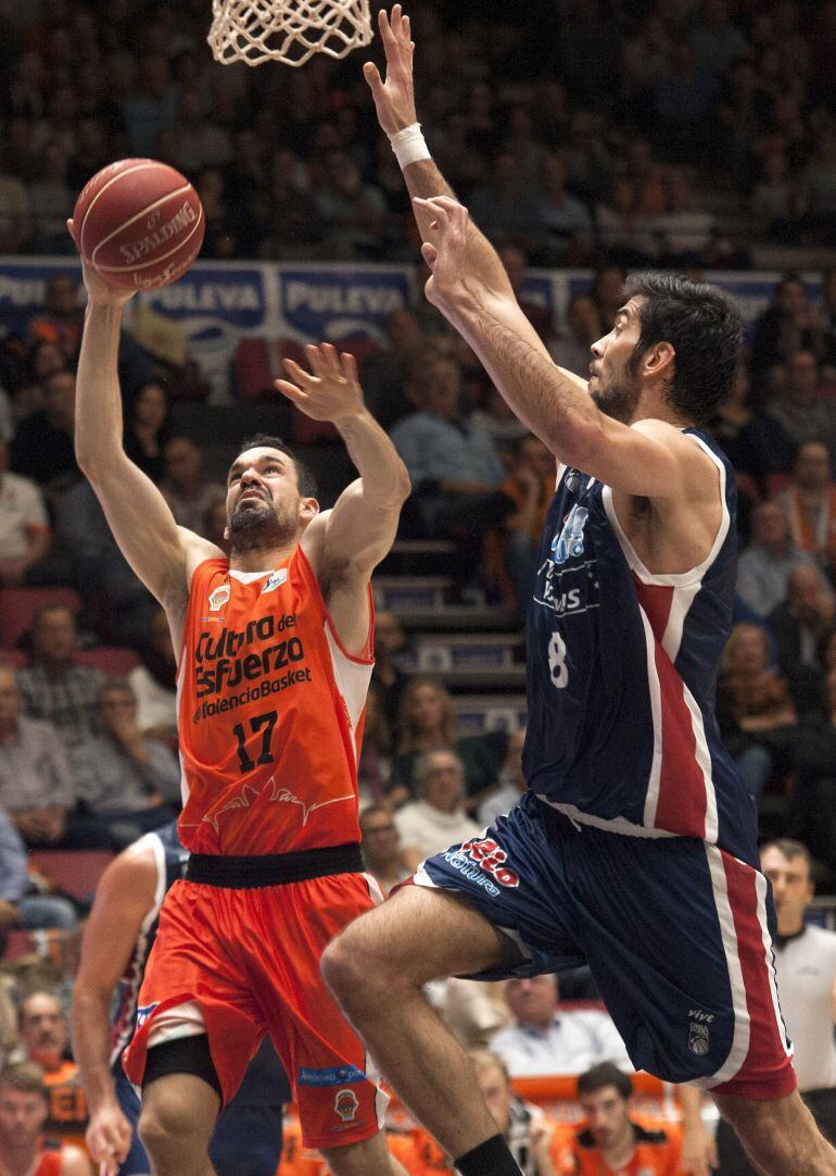 GRA260. VALENCIA, 31/10/2015.- El pívot del Rio Natura Monbus Obradoido Juan José Triguero (d) intenta un tapón al escolta del Valencia Rafa Martínez (i), durante el partido de la cuarta jornada de la Liga ACB que se juega hoy en el Pabellón Fuente de San Luis de Valencia. EFE/Miguel Ángel Ferrera