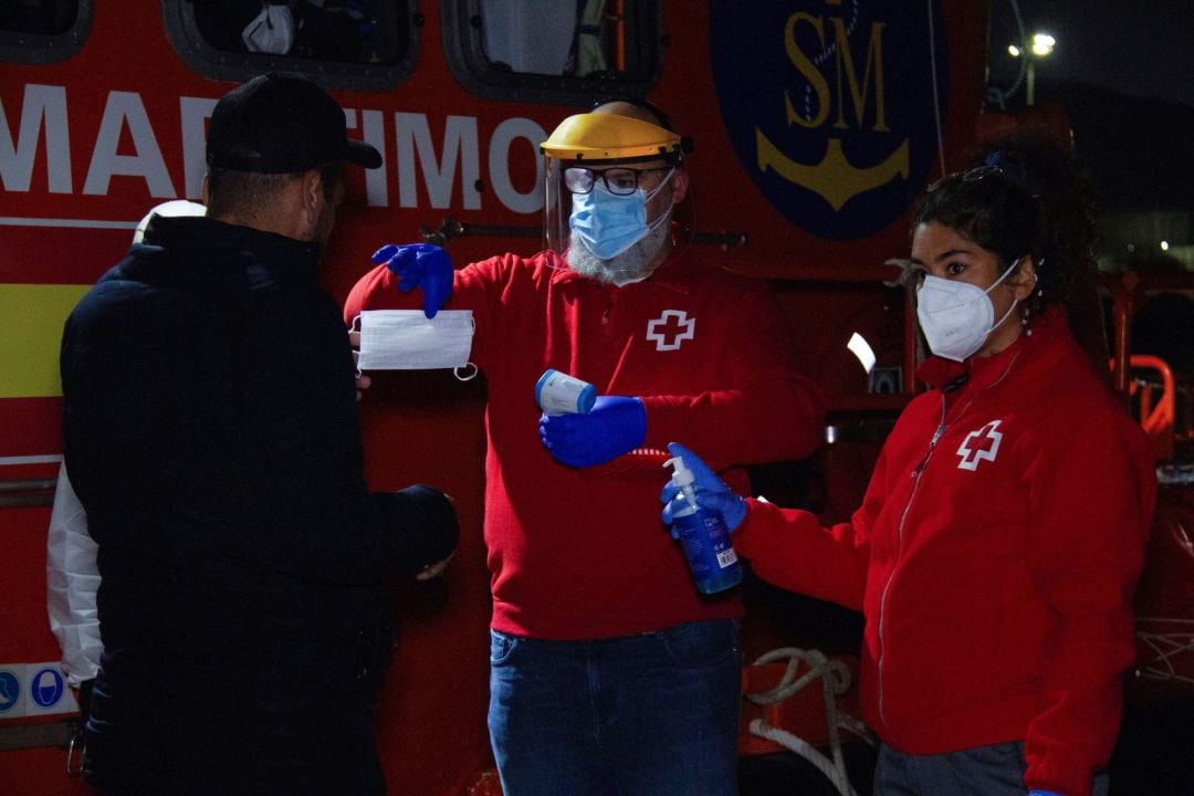 Voluntarios de Cruz Roja atiende a uno de inmigrantes rescatados por Salvamento Marítimo