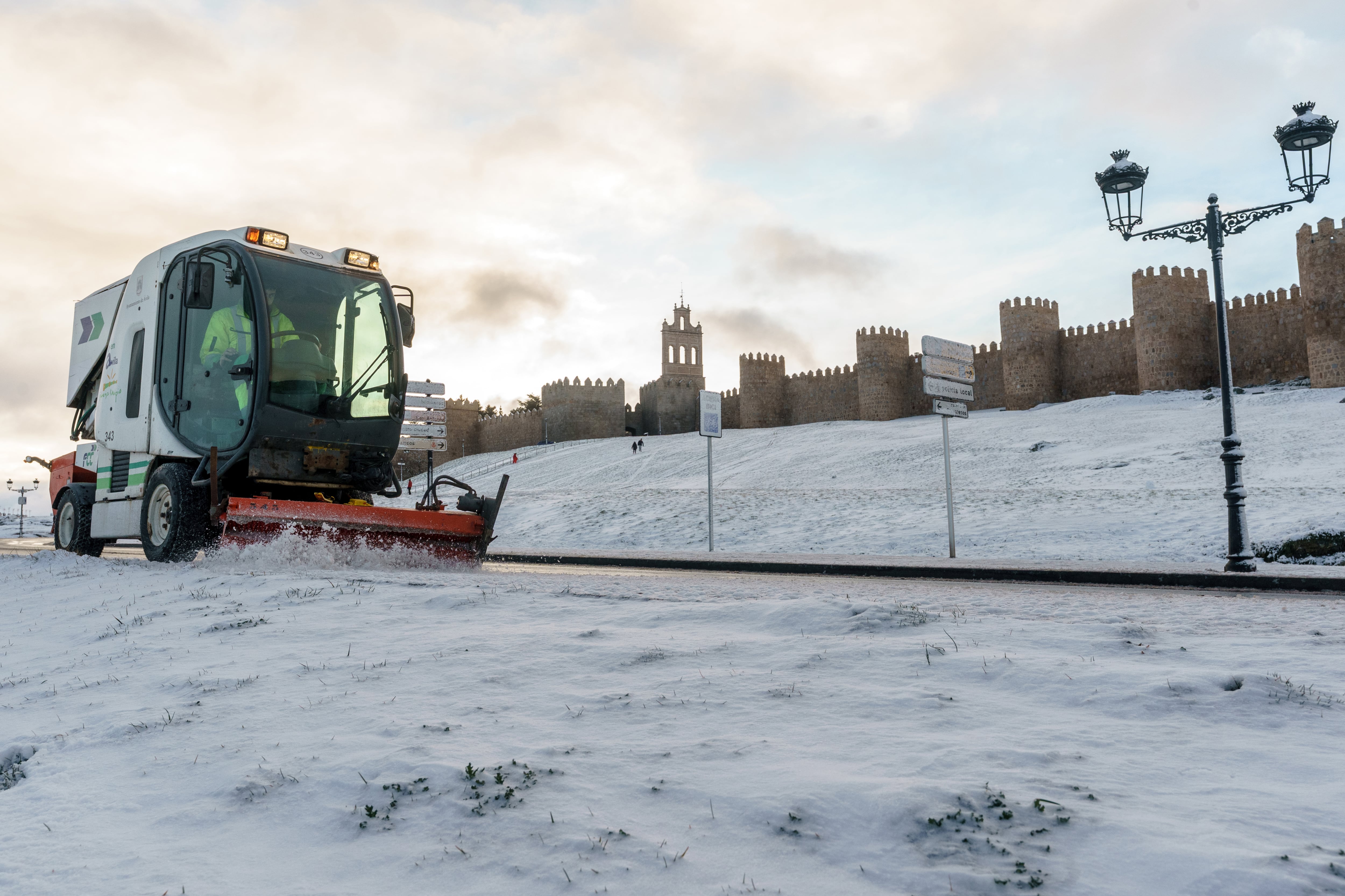 Una máquina quitanieves retira la nieve y el hielo en los alrededores del lienzo norte de la muralla de Ávila este sábado.