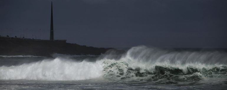 Una ola rompiendo contra las rocas del paseo marítimo de A Coruña.