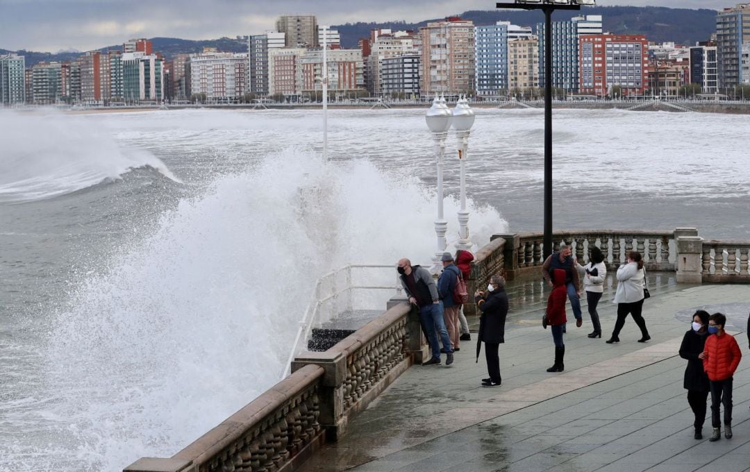 Vista del paseo de la playa de San Lorenzo de Gijón este domingo, jornada en la que la borrasca &quot;Bella&quot;, llega al Principado con lluvias y viento localmente fuertes y temporal en la costa. 