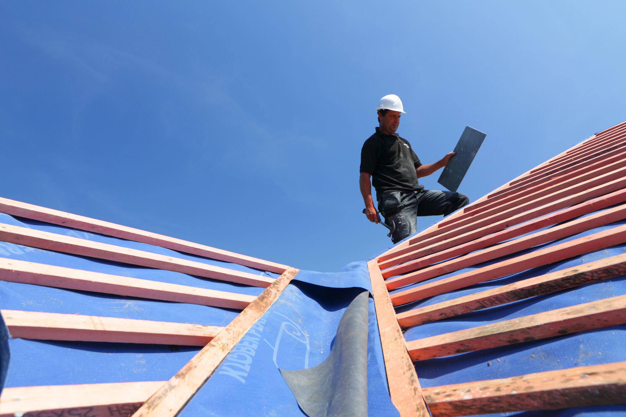 Un trabajador de la construcción realiza labores en un tejado