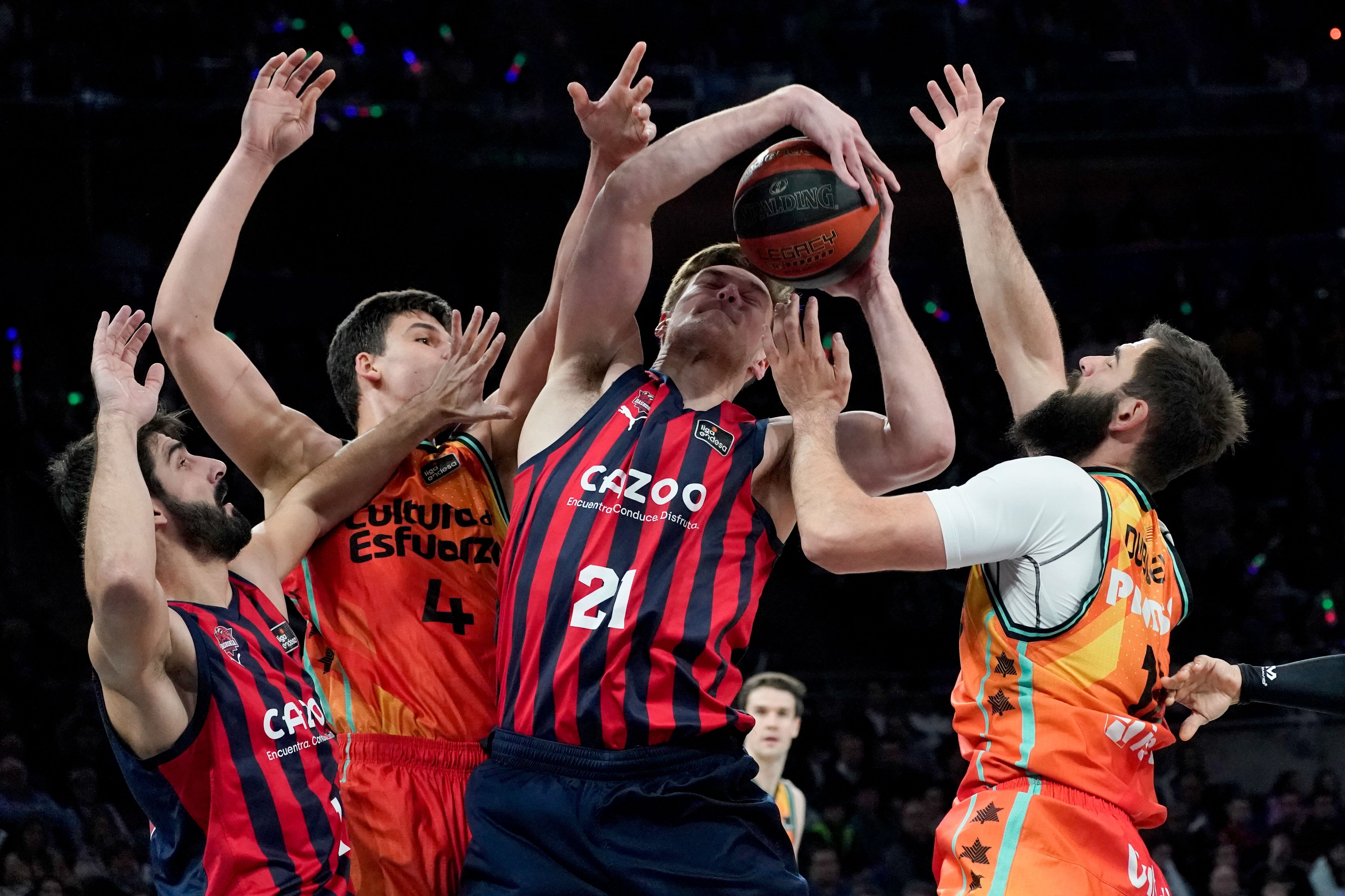 VITORIA, 08/01/2023.- El pivot estonio de Baskonia, Maik-Kalev Kotsar (c), disputa un rebote ante los jugadores de Valencia Basket, Jaime Pradilla (2i) y el montenegrino Bojan Dubljevic, durante el encuentro correspondiente a la jornada 15 de la liga Endesa disputado hoy domingo en el pabellón Fernando Buesa Arena de Vitoria. EFE / L. Rico.