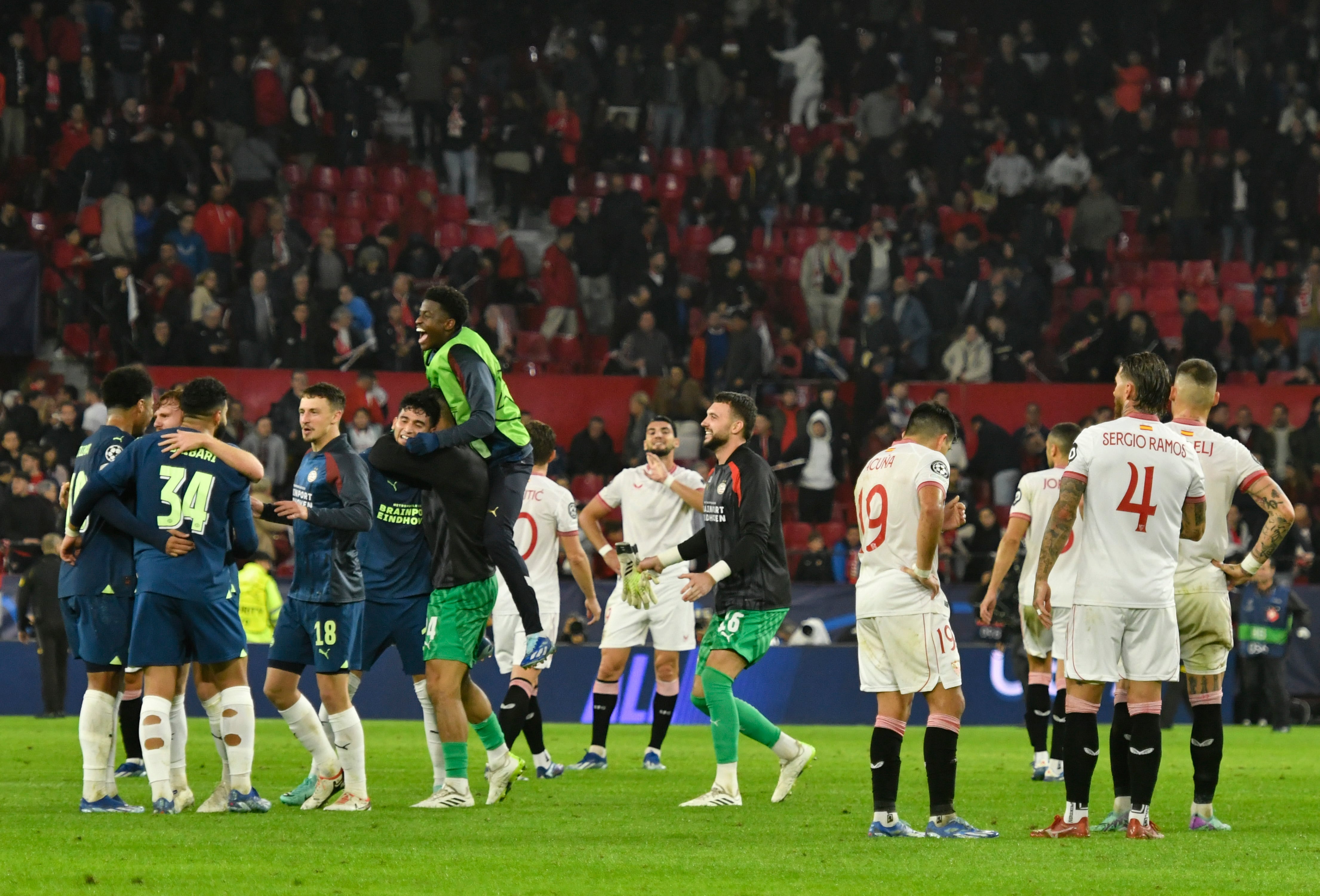 SEVILLA, 29/11/2023.- Los jugadores del PSV (i) celebran la victoria ante los del Sevilla, al término del partido de la fase de grupos de la Liga de Campeones que Sevilla FC y PSV Eindhoven disputan este miércoles en el estadio Ramón Sánchez-Pizjuán. EFE/Raúl Caro
