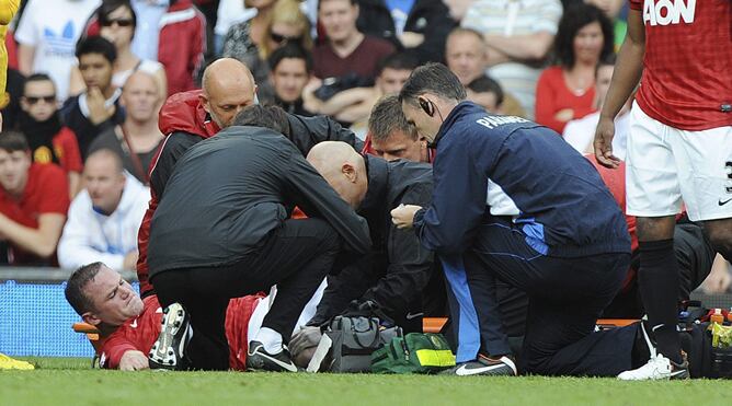 El delantero inglés del Manchester United, Wayne Rooney es atendido por los servicios médicos del club durante el partido correspondiente a la Premier League entre Manchester United y el Fulham