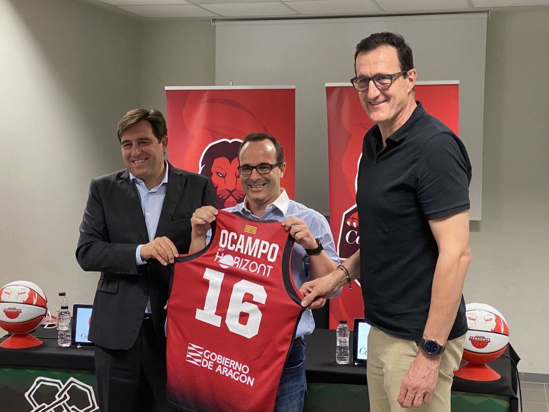 Diego Ocampo posa con su camiseta de Casademont Zaragoza junto al director deportivo y el presidente del Club