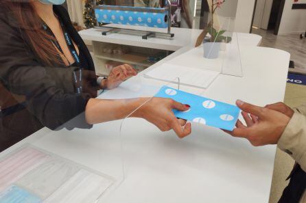 Entrega de mascarilla a un cliente