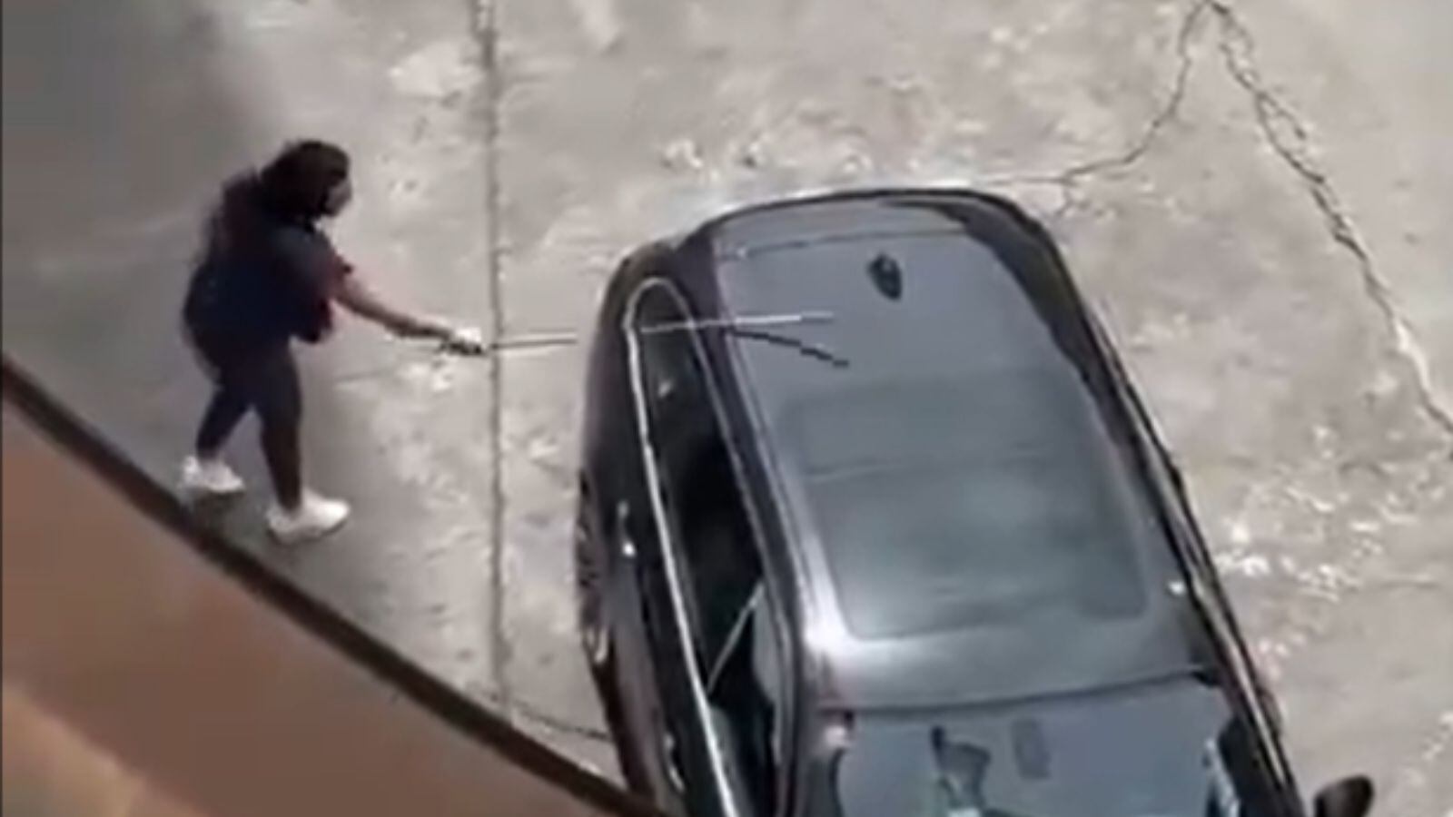 Fotograma de una mujer con un palo provocando daños en un vehículo estacionado en una gasolinera de Talavera de la Reina (Toledo)