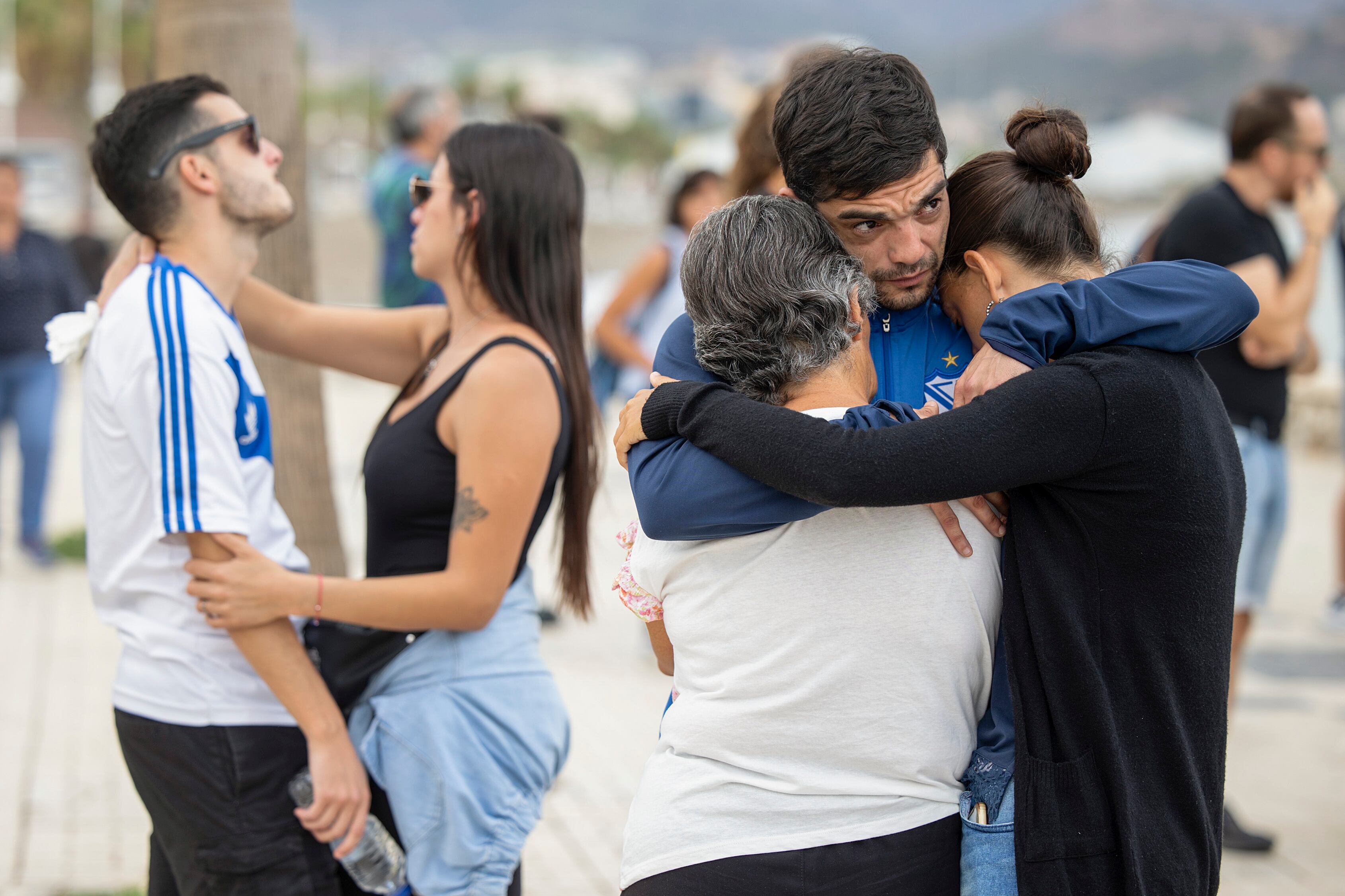 Francisco (d) y Nacho Soria (i), hermanos de Emmanuel Soria, que junto a Maximiliano Ludvickm, son los dos desaparecidos en la playa de Huelín cuando se encontraban practicando paddle surf el pasado día 27 de septiembre, se abrazan durante una concentración