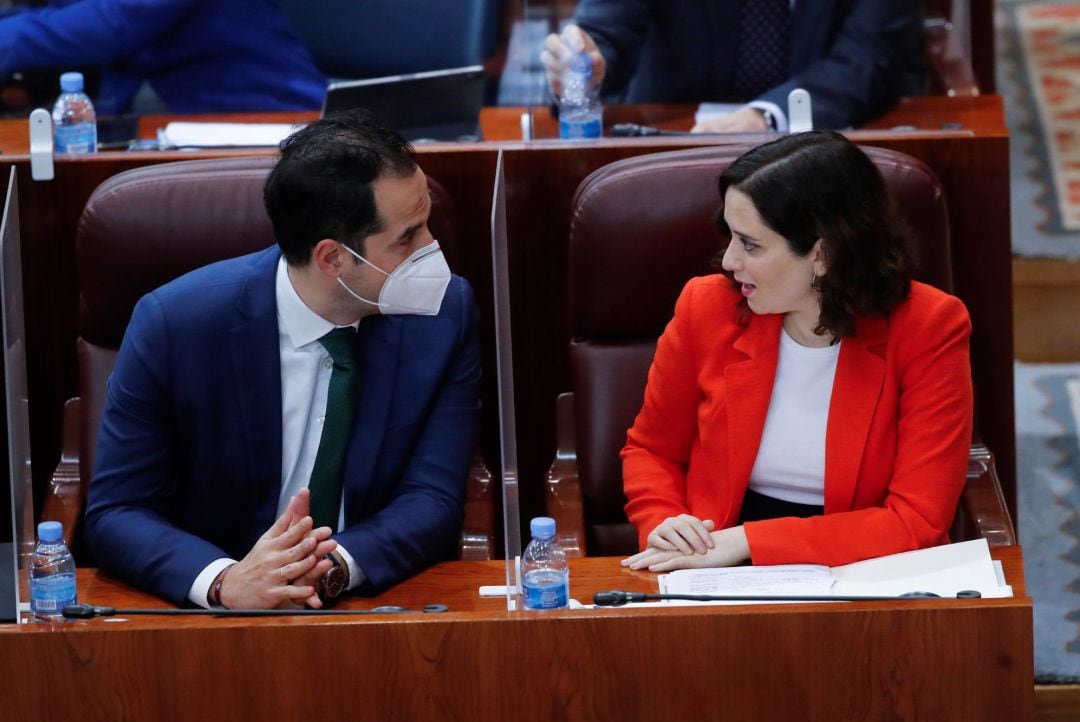 La presidenta de la comunidad de Madrid, Isabel Díaz Ayuso, y el vicepresidente, Ignacio Aguado, hablan minutos antes del inicio de la sesión plenaria extraordinaria de la Asamblea de Madrid, este jueves. 