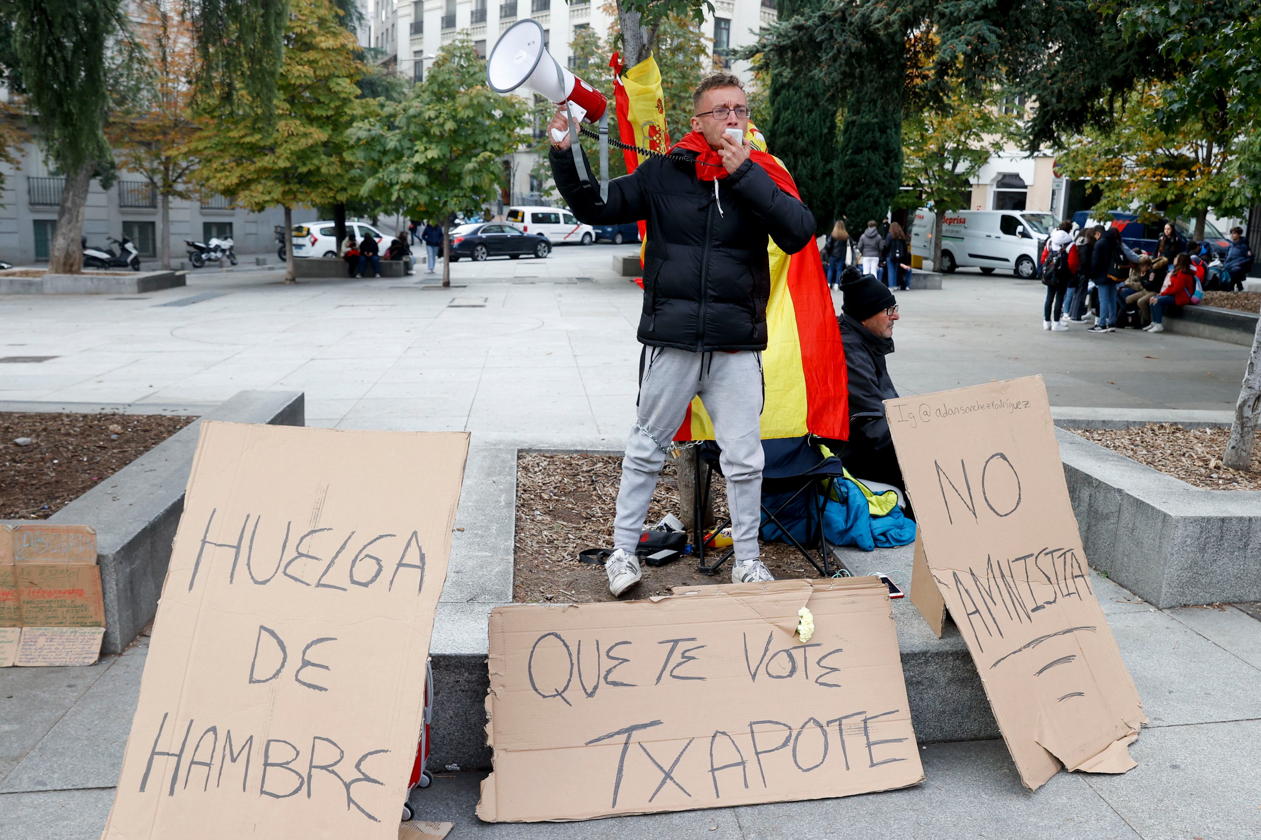 MADRID, 08/11/2023.- Un hombre de 28 años se ha encadenado a un árbol en la plaza de las Cortes, frente al Congreso, donde ha iniciado una huelga de hambre desde ayer en contra de la amnistía del procés porque asegura que contradice lo dicho por Pedro Sánchez en la campaña electoral. EFE/ Juan Carlos Hidalgo
