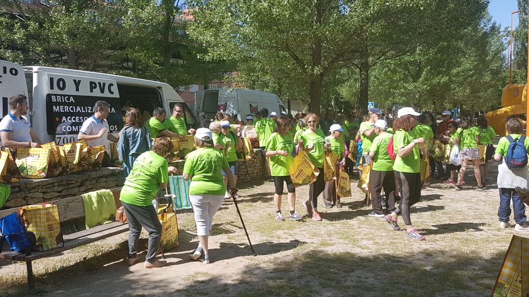 Participantes de la marcha a beneficio de Parkinson Segovia recogen su bocadillo al finalizar la caminata