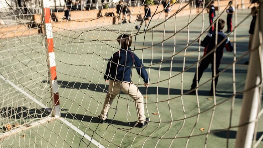 Varios niños en el patio de colegio.