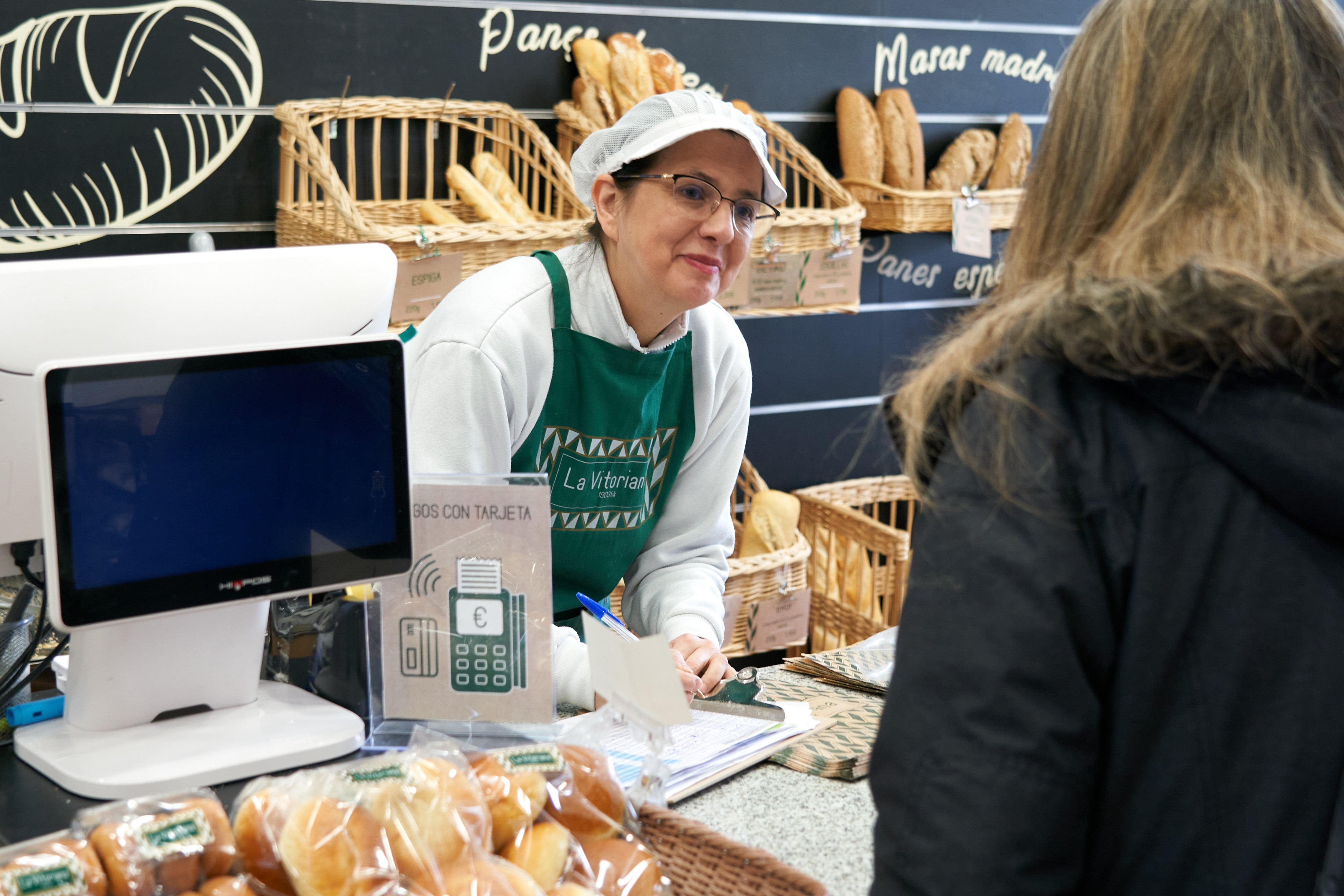 La empleada de una panadería atiende a su clientela