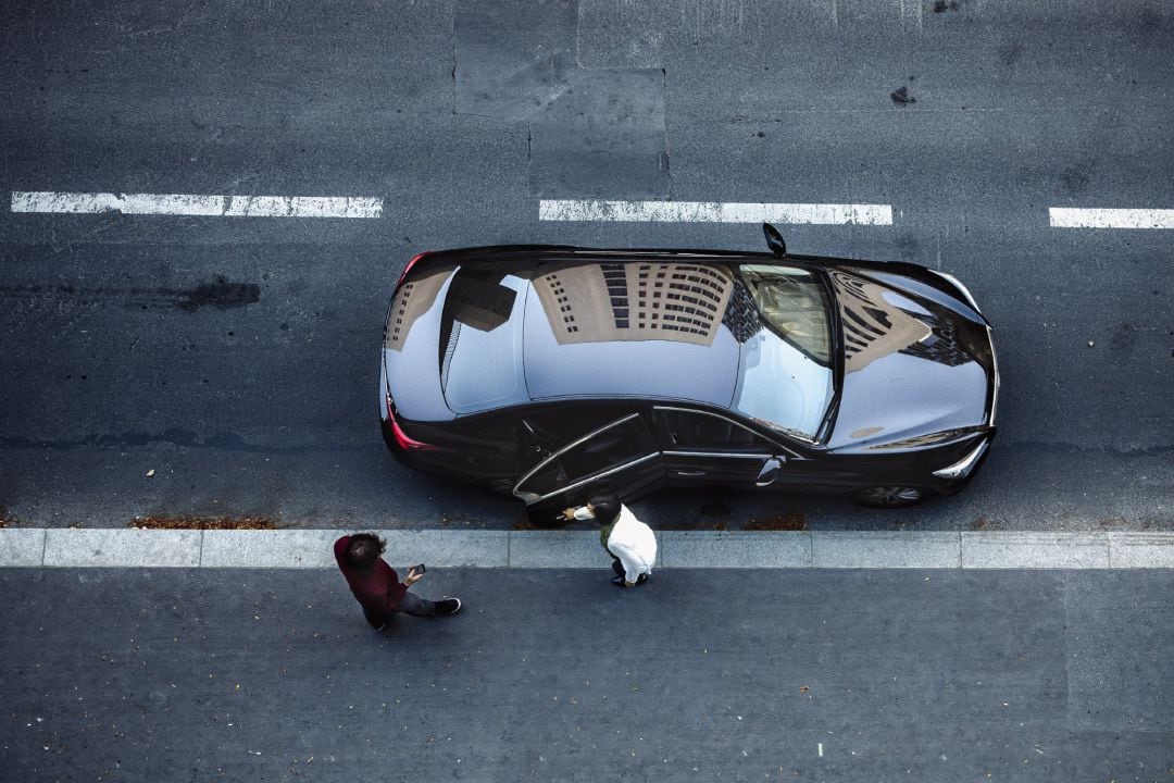 Un conductor abre la puerta del coche a alguien en Madrid.