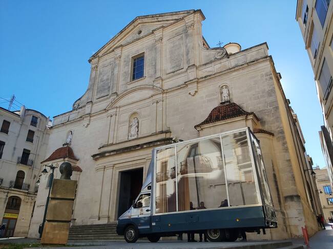 El vehículo en el que viaja la imagen de la peregrina de la Virgen de los Desamparados, conocido como 'Maremóvil' aparcado junto a la iglesia