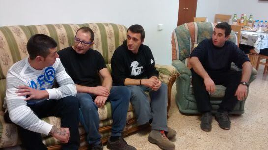 Quatre de les persones que viuen al pis conversen al menjador.