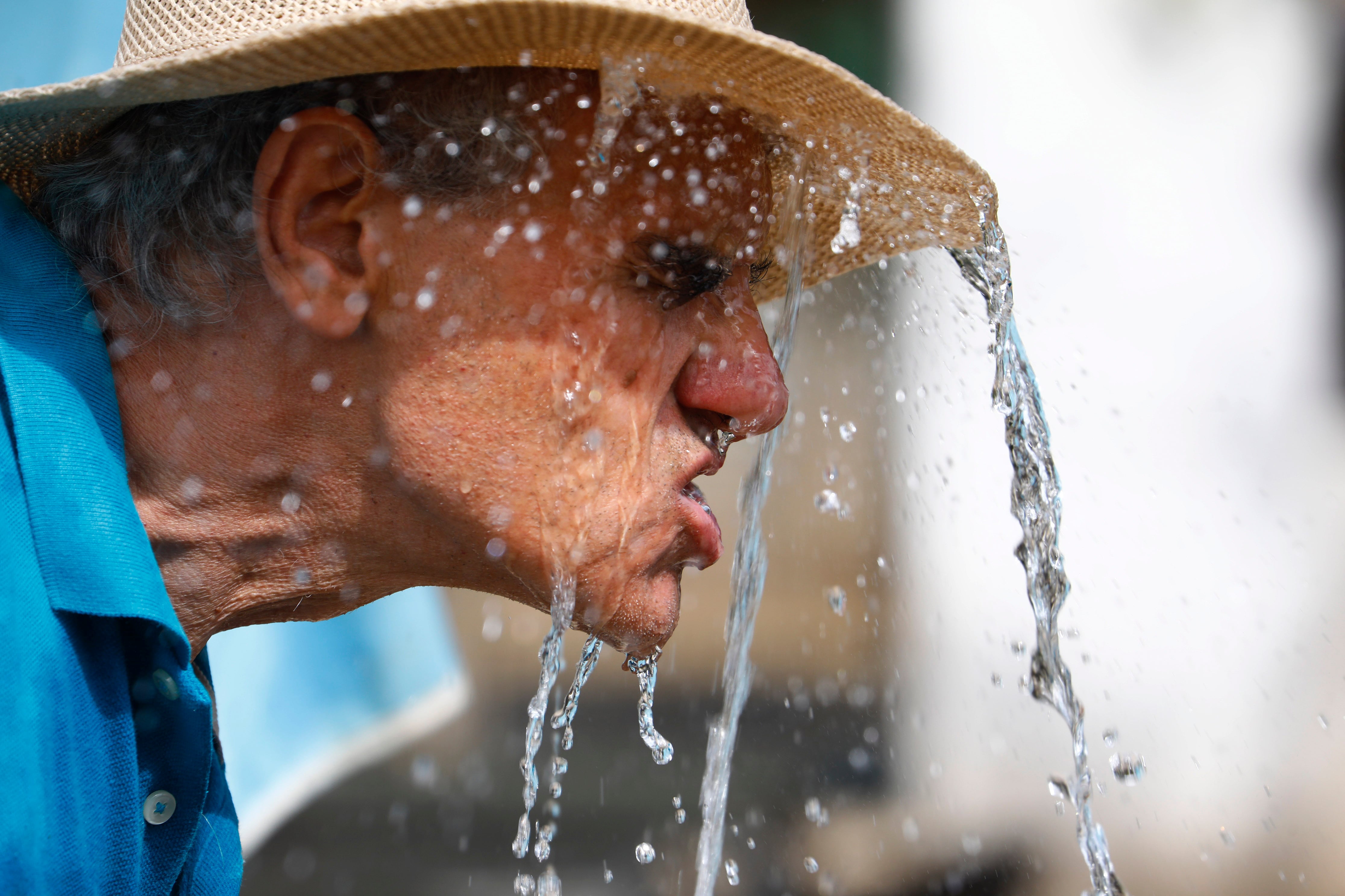 Un hombre se refresca en una fuente para aliviar las altas temperaturas este domingo en Córdoba.