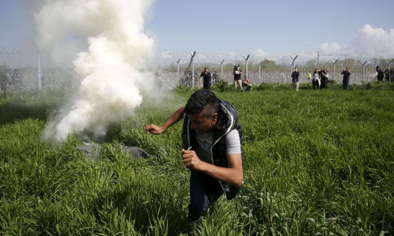 Una bomba lacrimógena cae cerca de un refugiado en la frontera macedonia. 