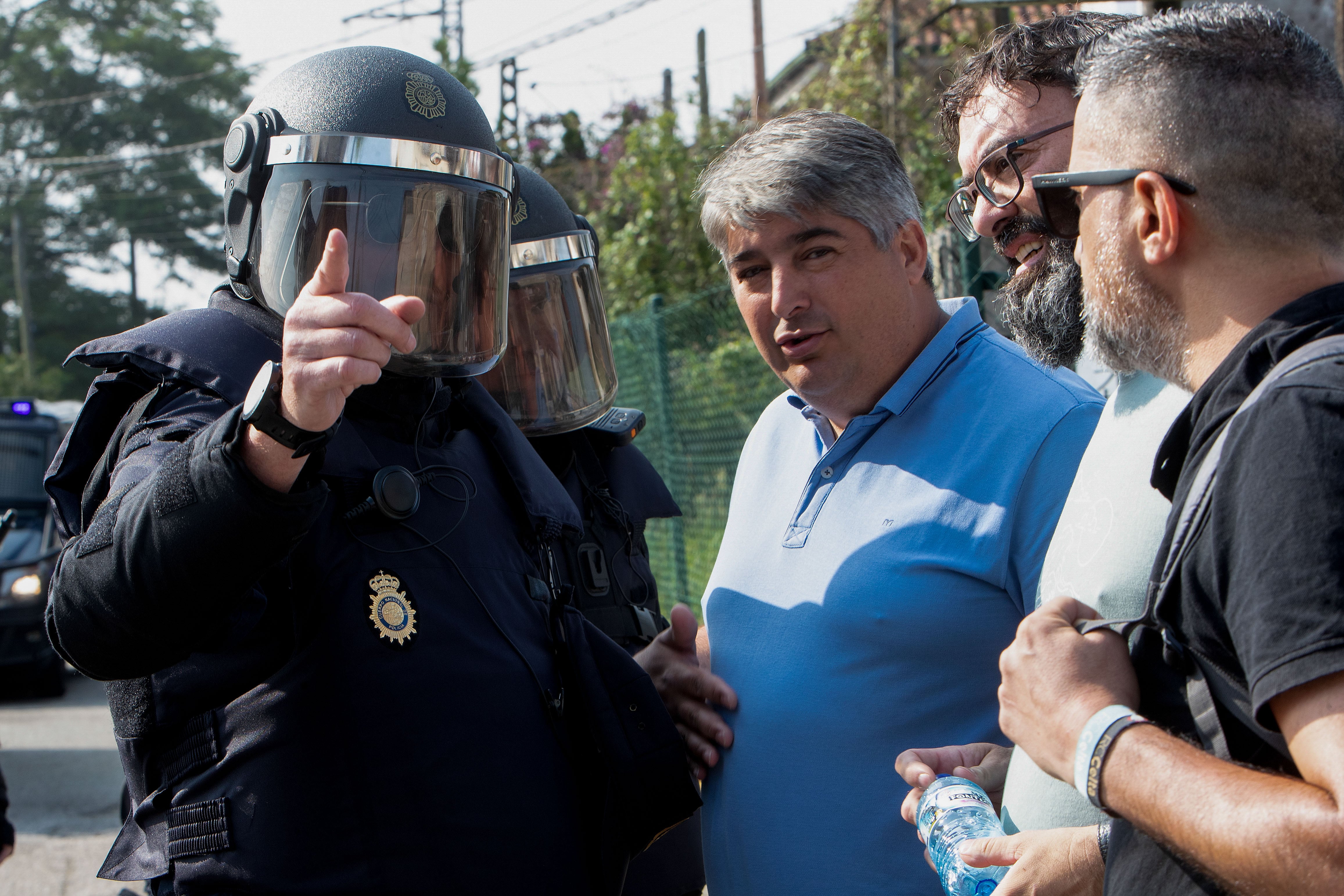 VIGO, 22/06/2023.- El secretario Xeral, Rubén Pérez conversa con un policía durante la manifestación que cientos de empleados del metal han llevado a cabo por un &quot;convenio digno&quot; este jueves, cerca del Instituto Ferial de Vigo (Ifevi), aunque sin poder acceder a sus inmediaciones por el cordón policial que les bloqueó el paso a medio kilómetro, un bloqueo al que respondieron llegando a cortar durante unos minutos la autopista AP-9. EFE/ Salvador Sas
