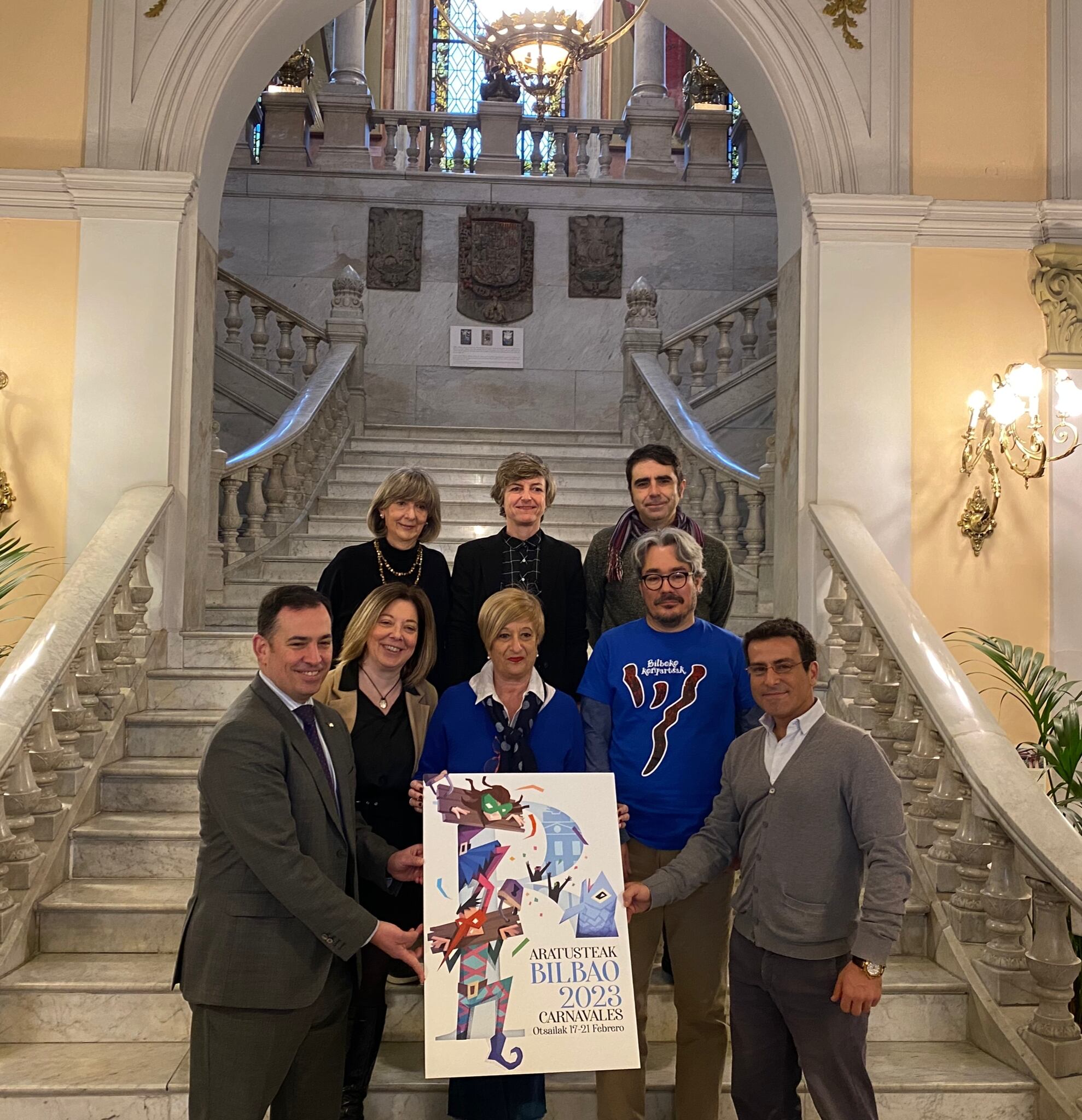 Jurado del concurso de carteles para los carnavales de Bilbao sostiene la obra ganadora.