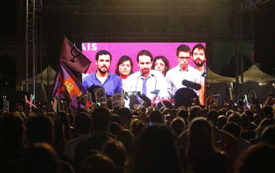 Simpatizantes de Unidos Podemos escuchan las declaraciones de su líder Pablo Iglesias.