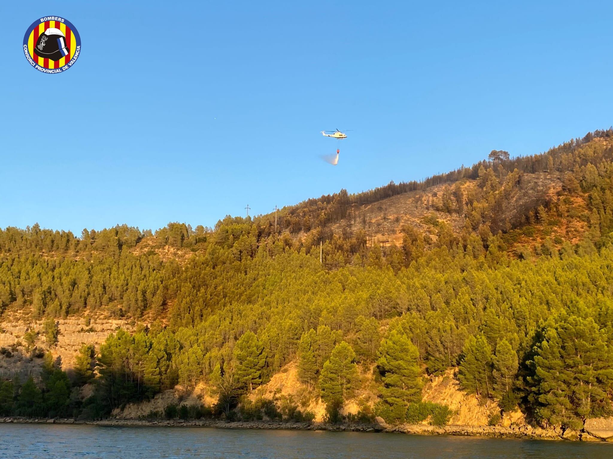 Un helicóptero descarga agua durante las labores de extinción del incendio de Cofrentes