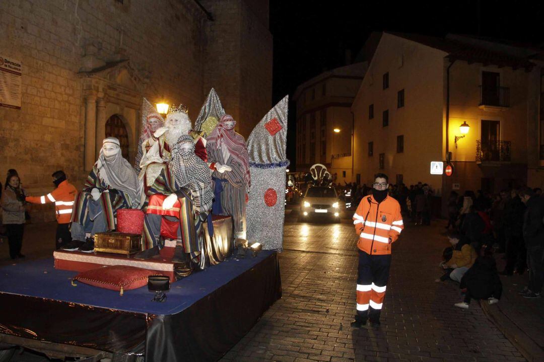 Un voluntario junto con una de las carrozas de la cabalgata