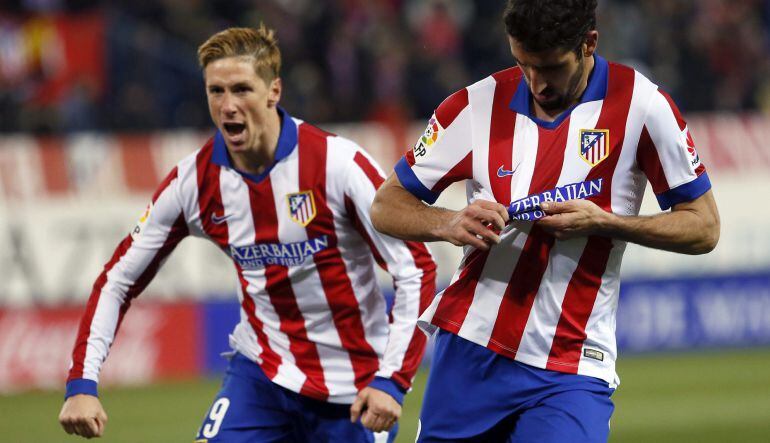 El centrocampista del Atlético de Madrid, Raúl García (d), celebra tras marcar gol frente al Real Madrid, durante el partido de ida de los octavos de final de la Copa del Rey que se juega esta noche en el estadio Vicente Calderón, en Madrid. A la izquierd