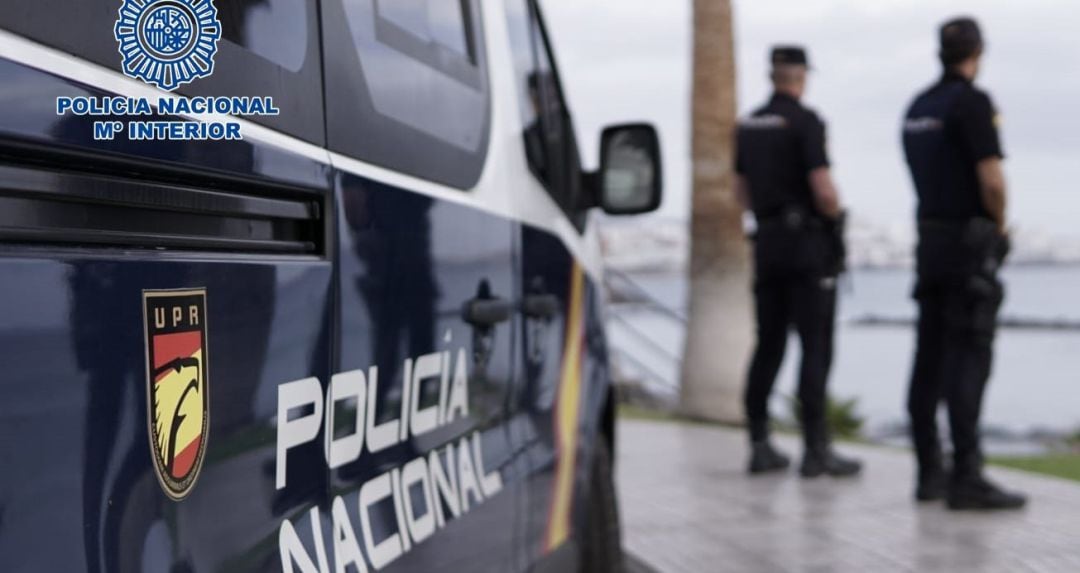 Agentes de la Policía Nacional junto a un coche patrulla