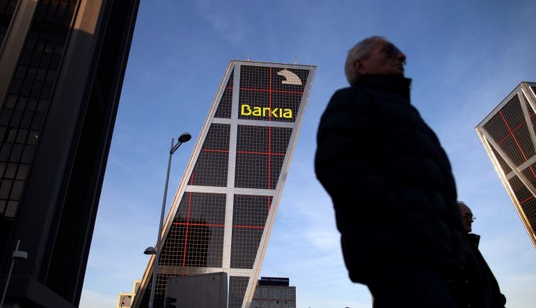 Ciudadanos caminan ante las oficinas centrales de Bankia en Madrid