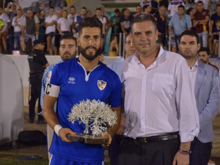 Rosales, capitán del Linares Deportivo, recibe el Trofeo del Olivo. 