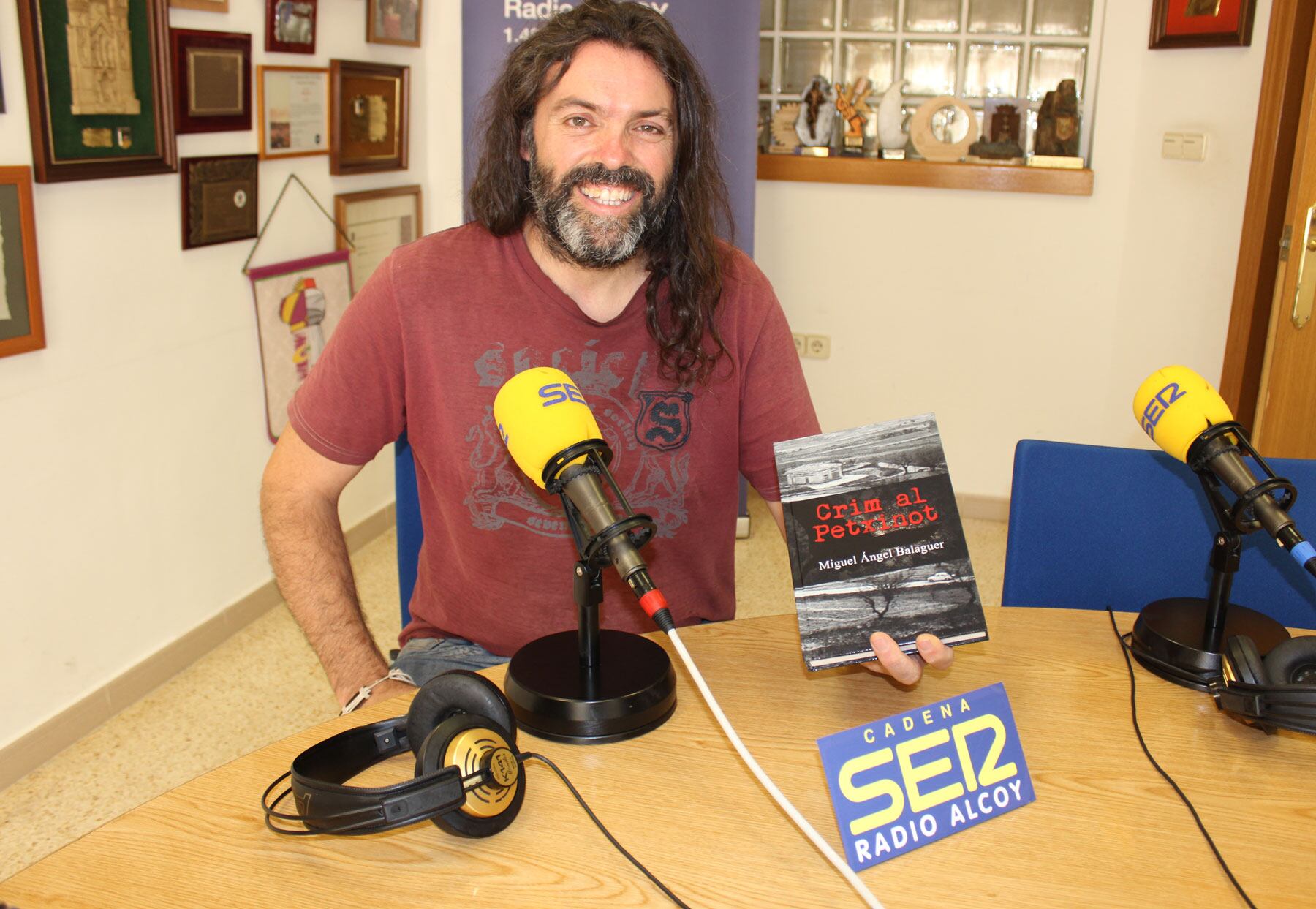 Miguel Ángel Balaguer mostra un exemplar del llibre en l'estudi central de Radio Alcoy