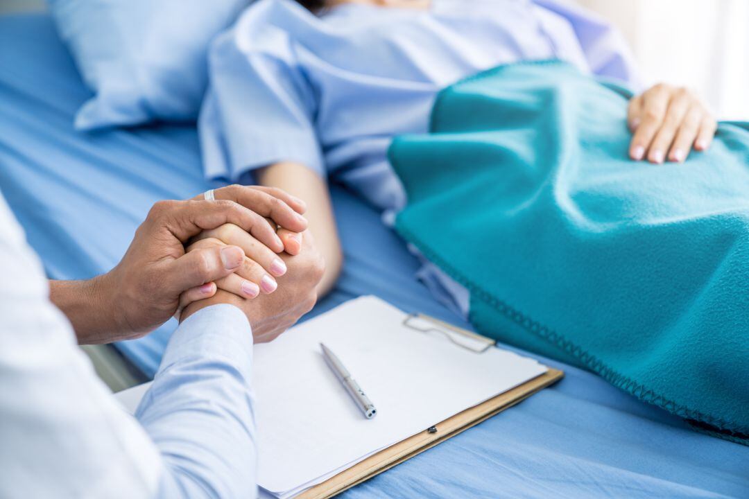 Un médico toma la mano de un paciente