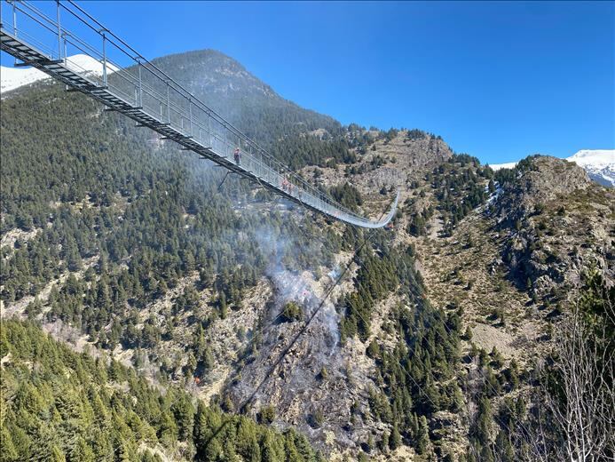 Columna de fum del petit incendi forestal declarat a sota del pont tibetà de Canillo.