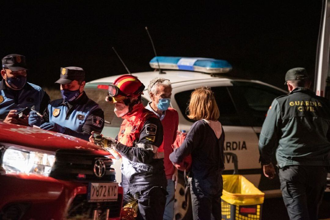 La senderista ya rescatada, junto a los servicios de emergencia.