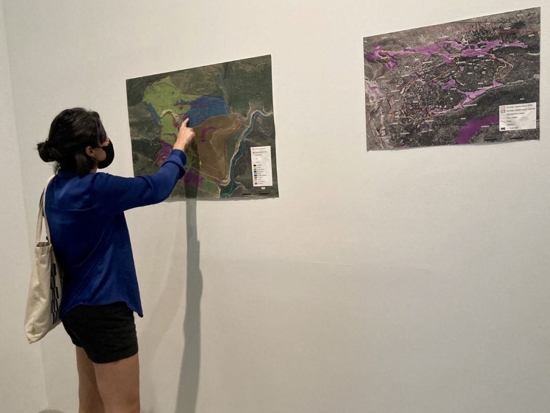Maddi Barber (Lakabe, 1988), codirectora de 'Paraíso', señala la ubicación donde se encuentra la pinada del Valle de Arce en uno de los mapas de la exposición