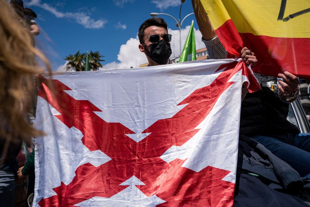 Exhibición de una bandera con el aspa de Borgoña en una manifestación de ultraderecha.