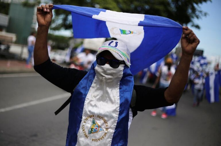 Un hombre camuflado con la bandera de Nicaragua y gafas de sol durante una de las manifestaciones en contra del Gobierno de Daniel Ortega