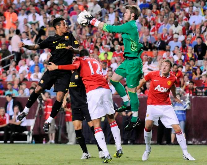 El portero del Manchester United, David De Gea, se hace con el balón ante el barcelonista Thiago Alcántara.