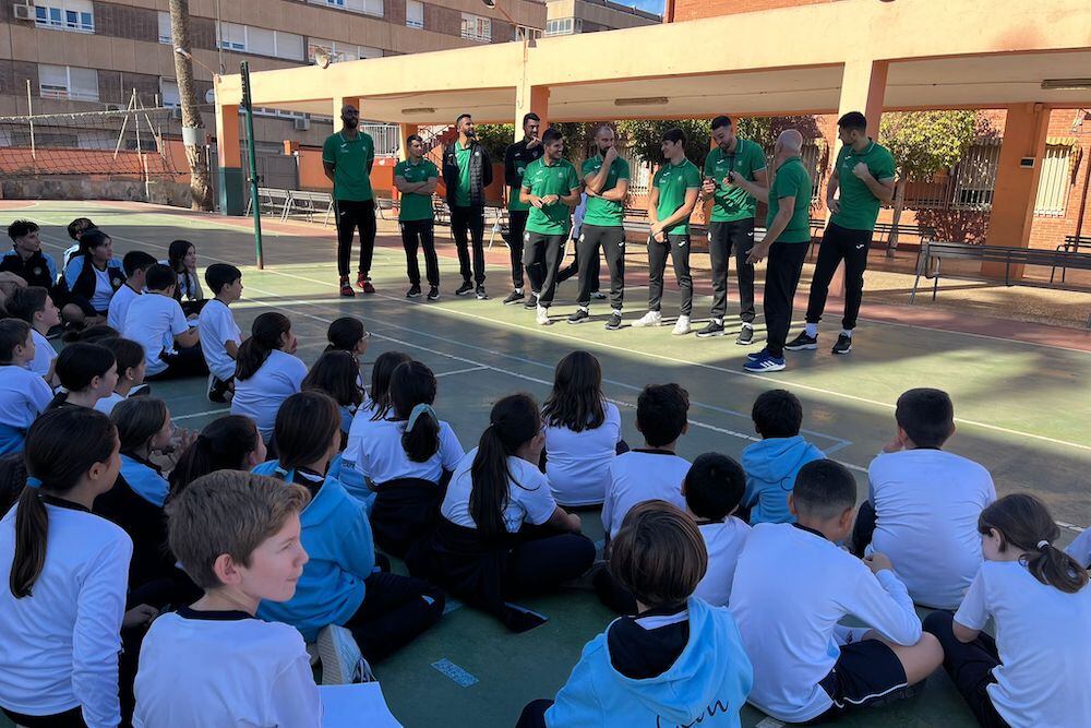 Los jugadores y técnicos del Unicaja dando clase.