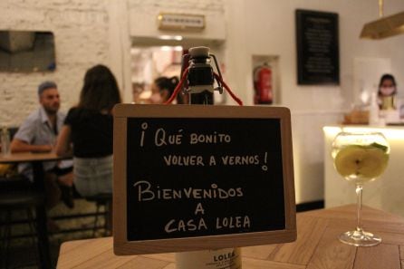 Un cartel da la bienvenida a los clientes de Casa Lolea. Al lado vemos una sangría hecha con vino blanco, una de sus cinco variedades.