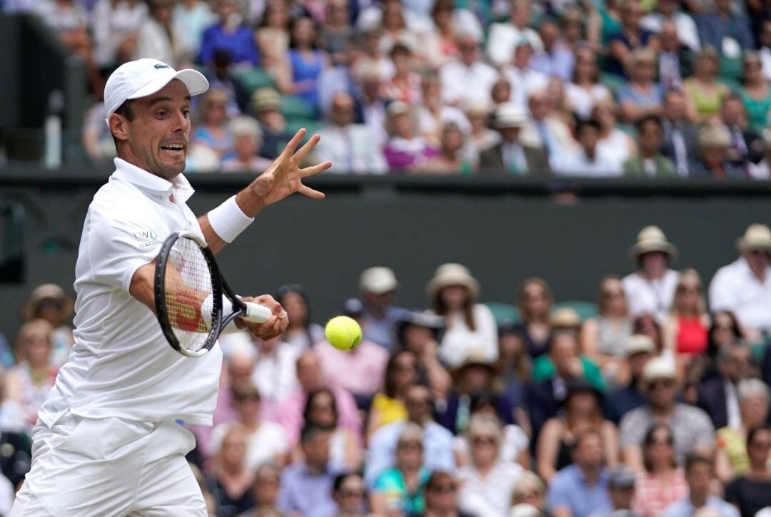 Roberto Bautista golpea una pelota ante Djokovic.