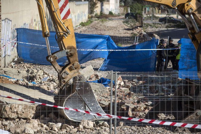 Un empleado de la construcción de 34 años, en la imagen cubierto con una lona azul, ha fallecido esta mañana sepultado por un muro que se estaba derribando en el marco de las obras de ampliación del colegio Ave María de la pedanía valenciana de Benimàmet