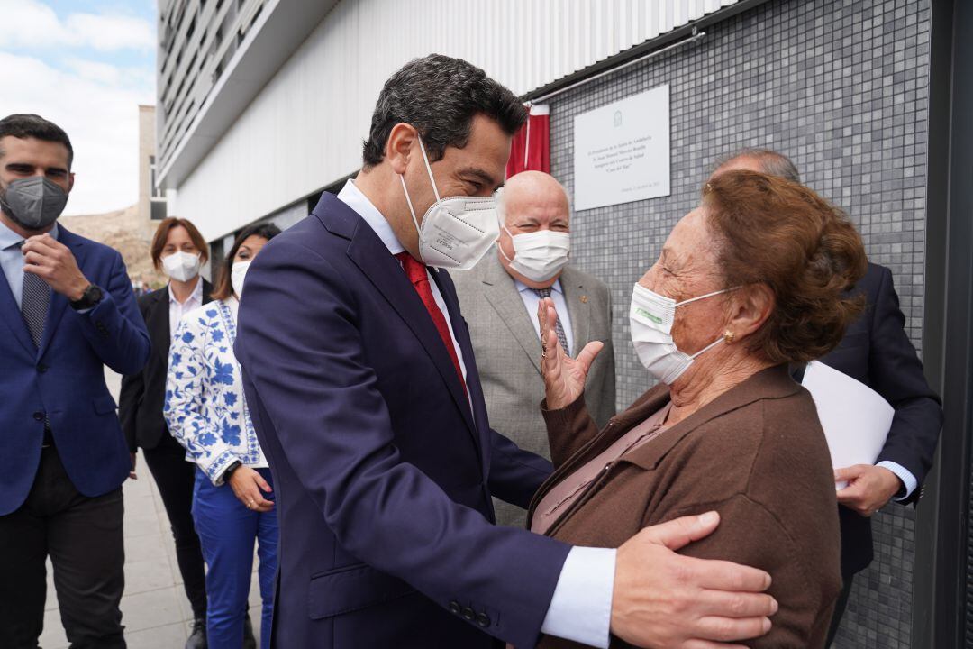 El presidente andaluz, Juan Manuel Moreno, saluda a una vecina al inaugurar el Centro de Salud Casa del Mar, situado en el barrio almeriense de Pescadería-La Chanca