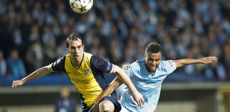 El jugador del Malmö Isaac Kiese Thelin (dcha) pelea por el control del balón con el defensa uruguayo del Atlético de Madrid, Diego Godín, durante el partido del grupo A de la Liga de Campeones disputado en el New Stadium de Malmo, Suecia, el 4 de noviemb