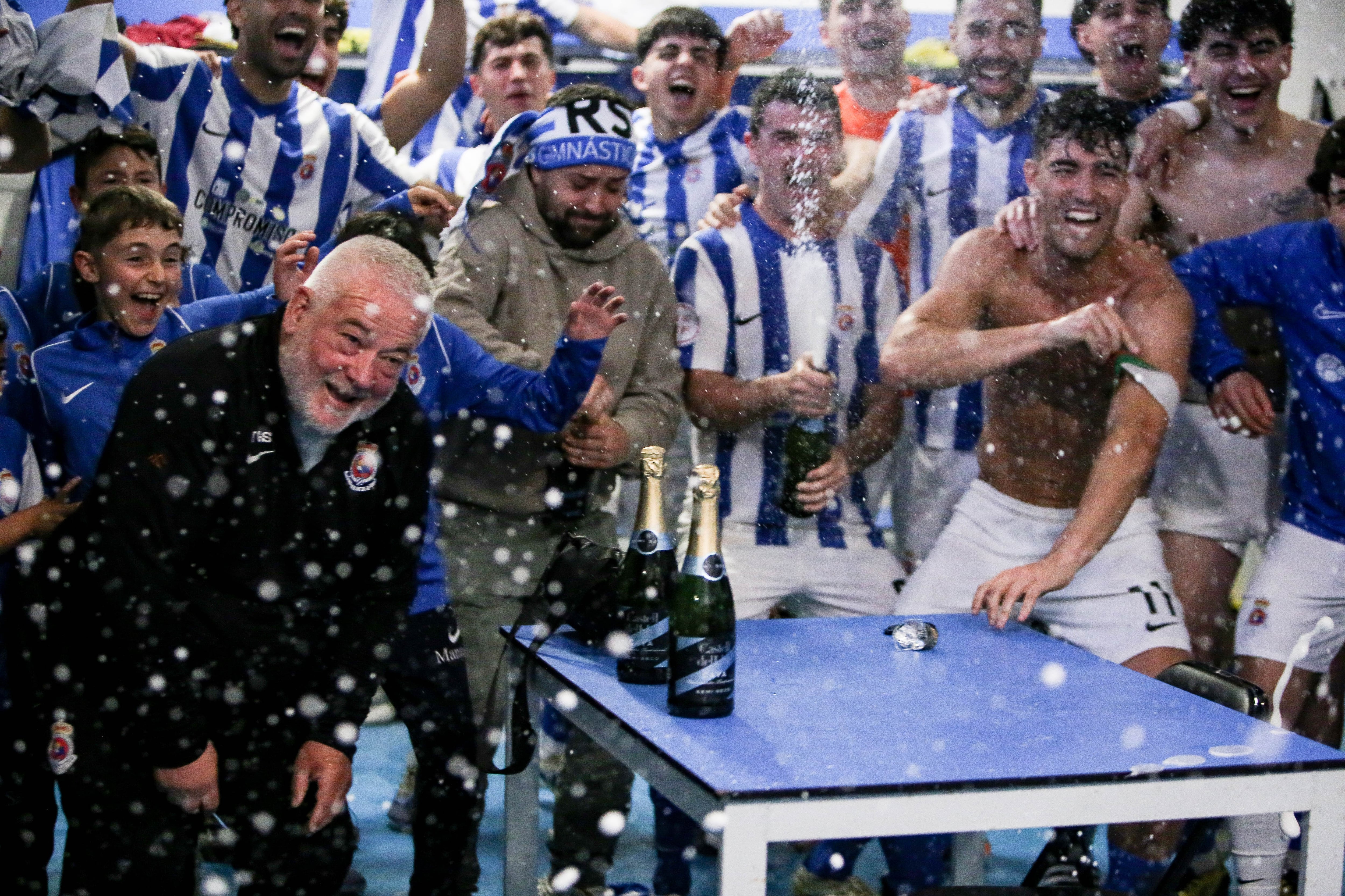 Los futbolistas de la Gimnástica celebran el ascenso en el vestuario de El Malecón
