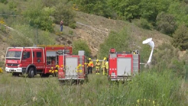 Efectius dels bombers al costat de les restes de l'ultralleuger estavellat aquest dimecres al costat de l'aeroport de la Seu d'Urgell.