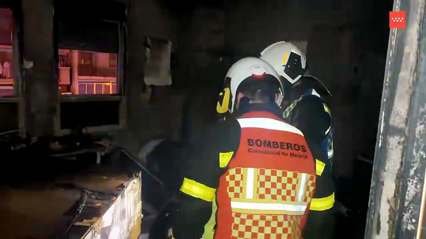 Dos bomberos inspeccionan la habitación calcinada en Leganés